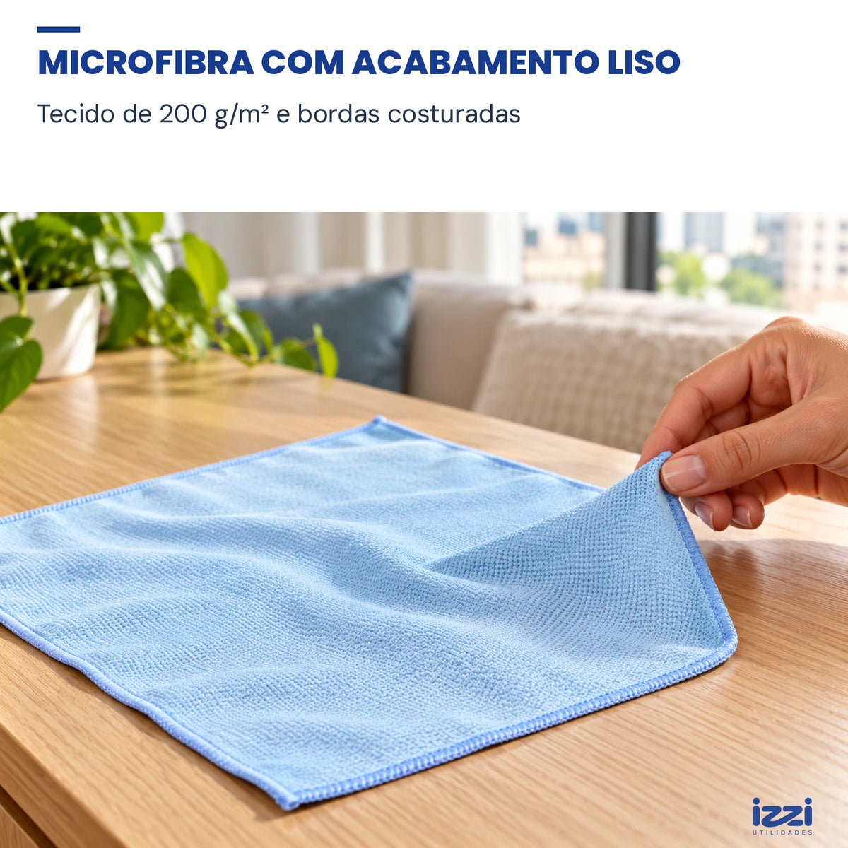Detalhe da textura de microfibra azul e da borda costurada, com uma ponta levantada pela mão.